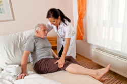 companion assisting an elderly in bed